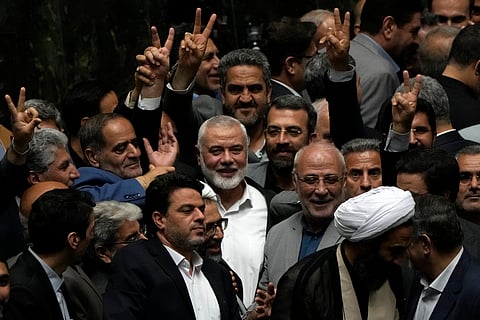 Palestinian Hamas chief Ismail Haniyeh, center, flashes a victory sign as he is surrounded by a group of Iranian lawmakers after the conclusion of the swearing-in ceremony of newly-elected Iranian President Masoud Pezeshkian at the parliament in Tehran, Iran, Tuesday, 30, 2024